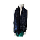 Mannequin wearing a navy paisley patterned scarf with fringe on a white background