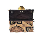 Black pouch with gold and beige patterned flap on a white background