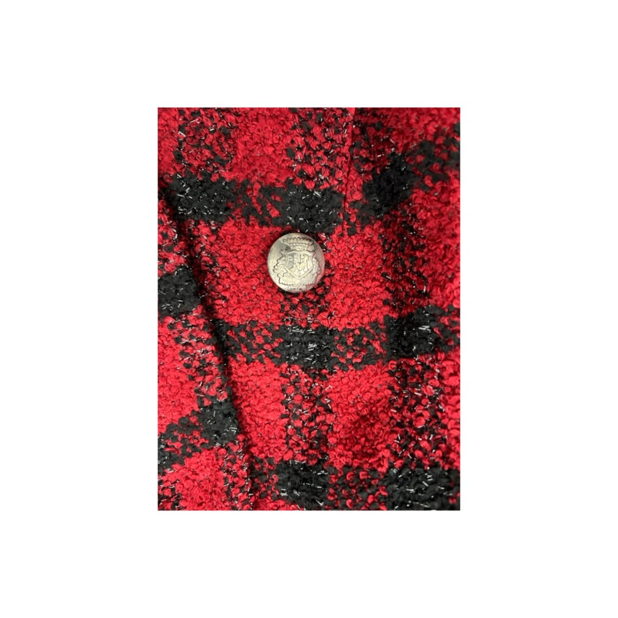 Red and black checkered fabric with a button on a white background