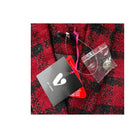 Red and black checkered fabric with a black card and pink item on top