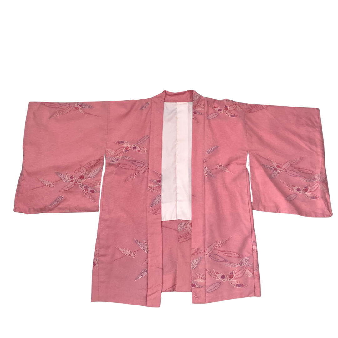Pink kimono with floral embroidery on a white background
