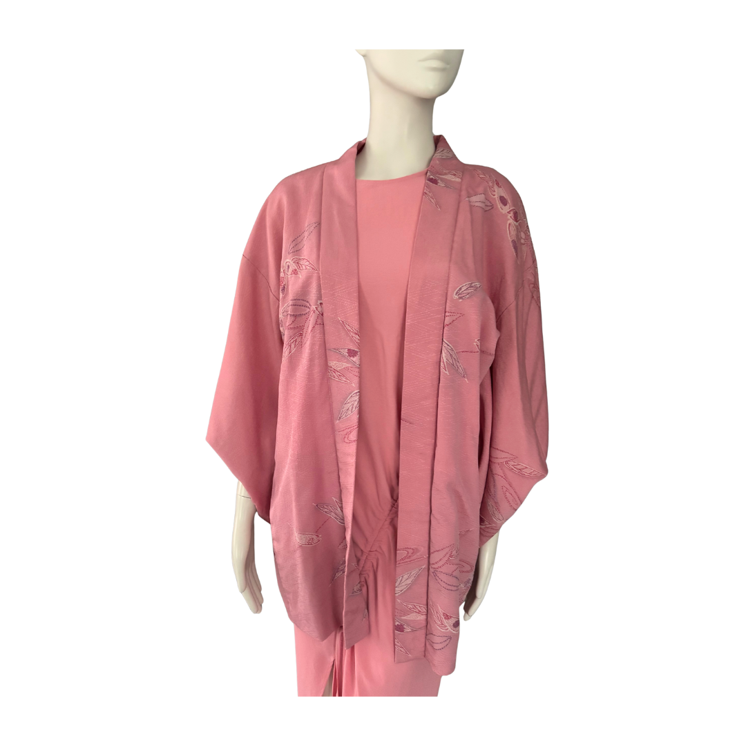 Mannequin wearing a pink kimono-style garment with floral patterns on a white background