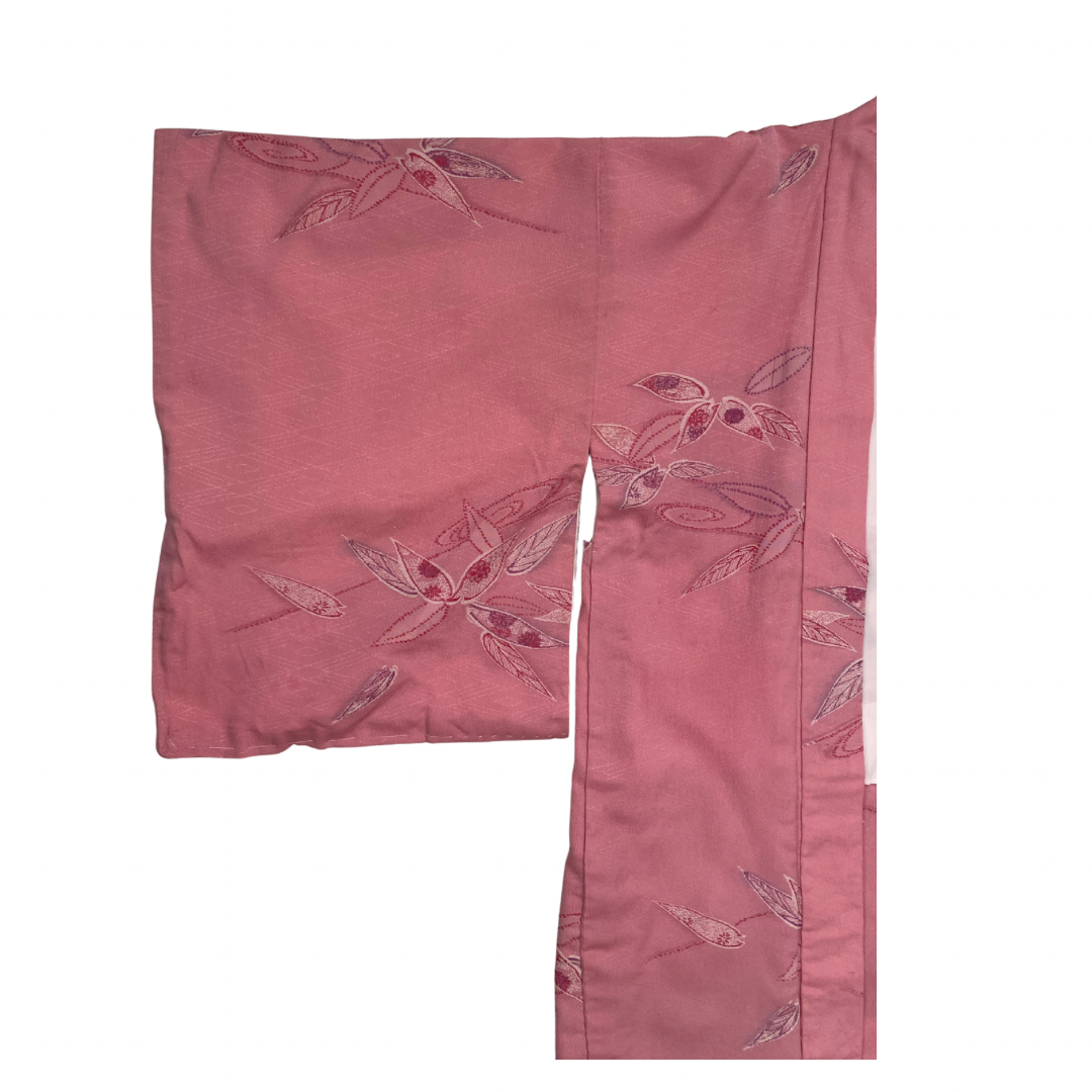 Pink fabric with floral embroidery on a white background