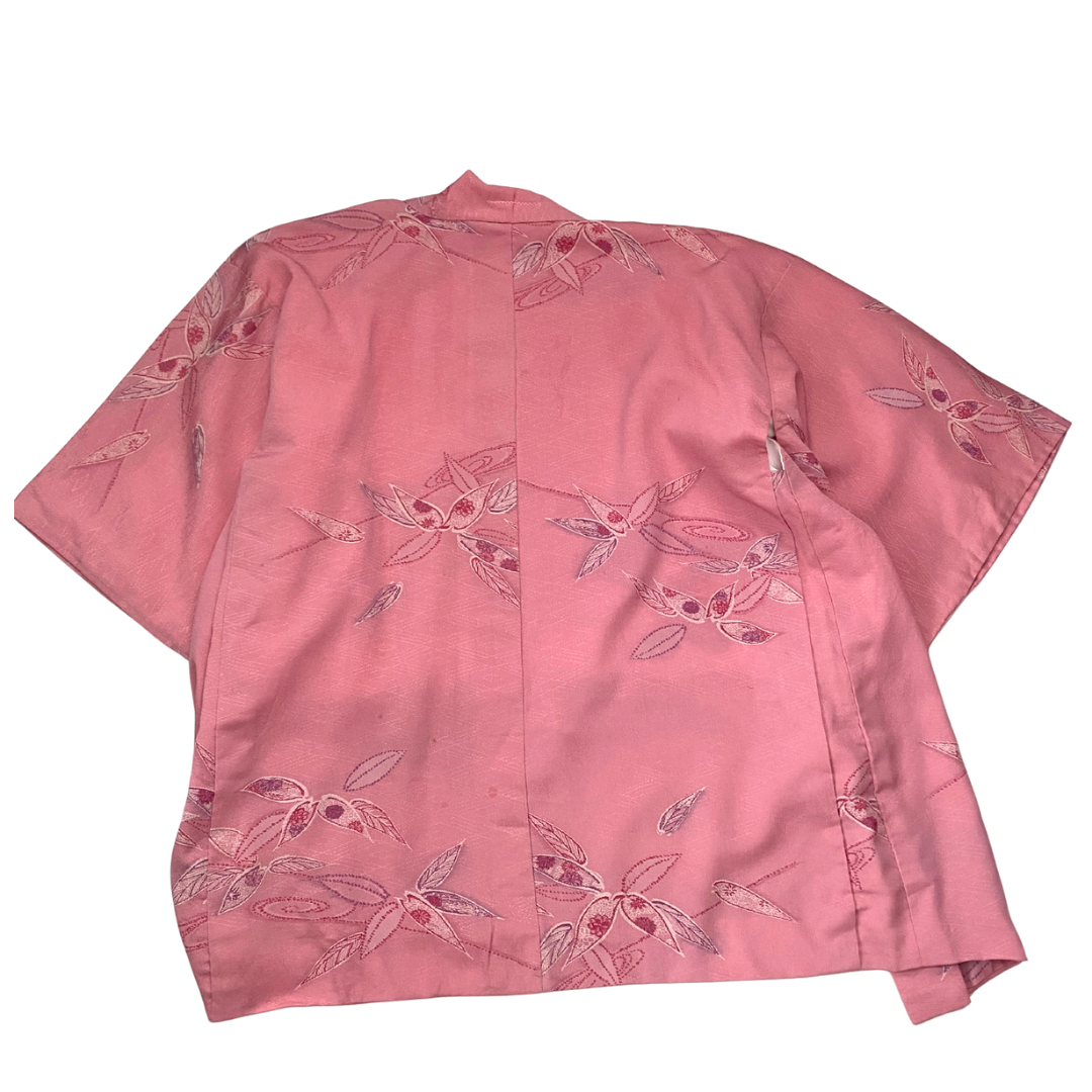 Pink shirt with floral embroidery on a white background
