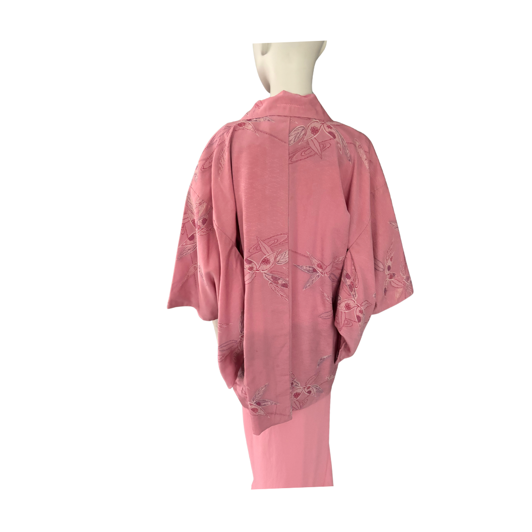 Pink outfit with floral embroidery on a mannequin against a white background