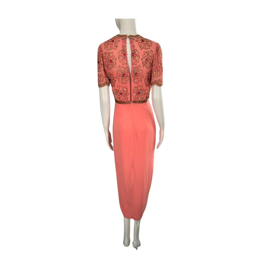 Coral dress with intricate top on a mannequin against a white background