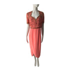 Coral dress with lace detailing on a mannequin against a white background