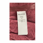 Close-up of a Zadig & Voltaire label on a burgundy leather product.