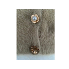 Gold buttons with a pearl on a textured cardigan