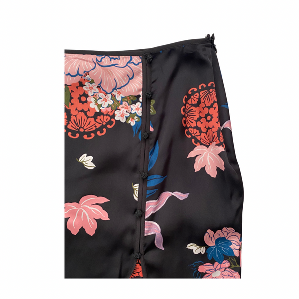 Black skirt close-up with colorful floral patterns on a white background