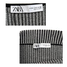 Two black and white striped socks with Zara labels on a white background