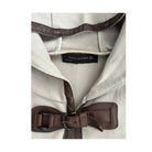 Close-up of a Zara Woman coat with a brown belt and visible label.