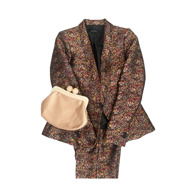Floral patterned suit with a beige handbag on a white background