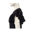 Black knitted dress shoulder on a mannequin against a white background