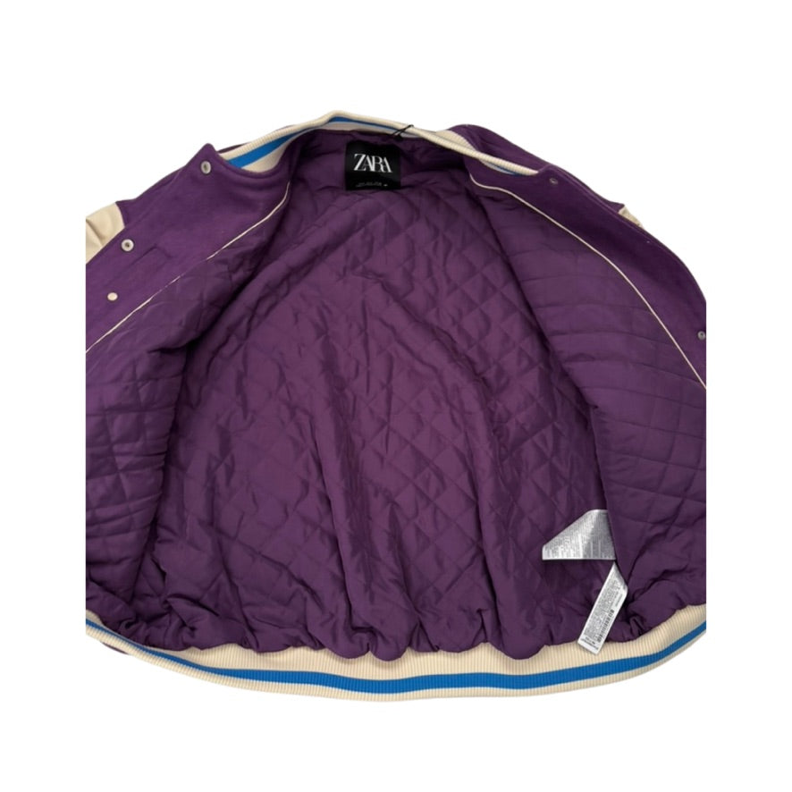 Purple quilted jacket with brand label on a white background